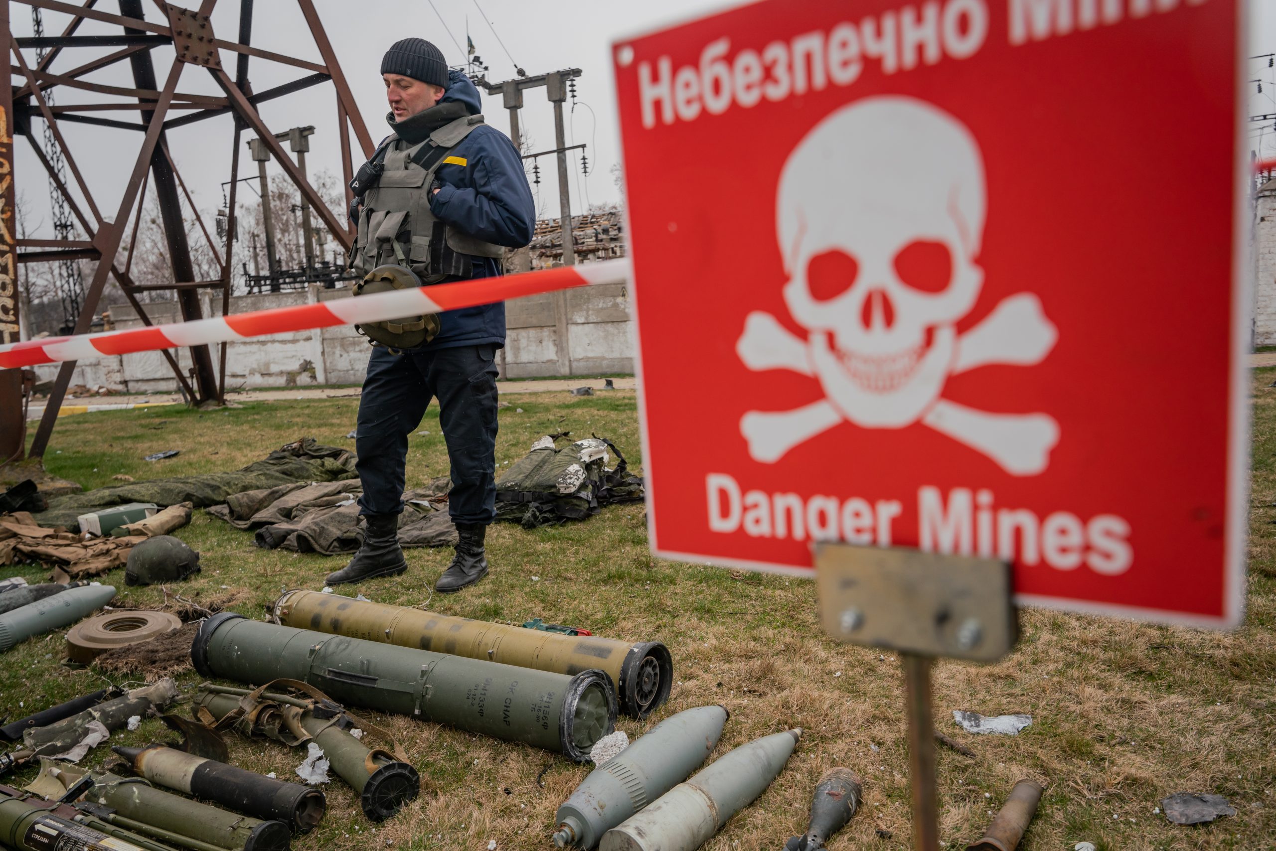 Ukraiński saper sprawdza rosyjskie pociski znalezione w dzielnicy mieszkalnej w Buczy.